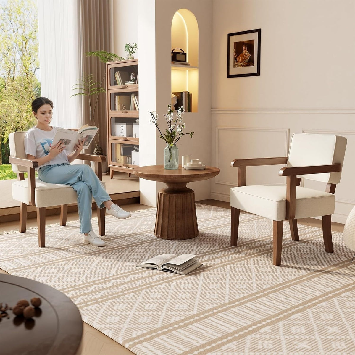Two mid-century solid wood armchairs with beige cushions in a living room