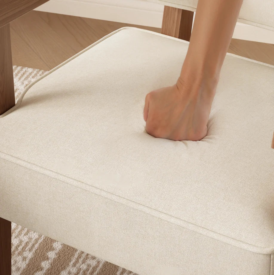 Hand pressing the padded armchair seat
