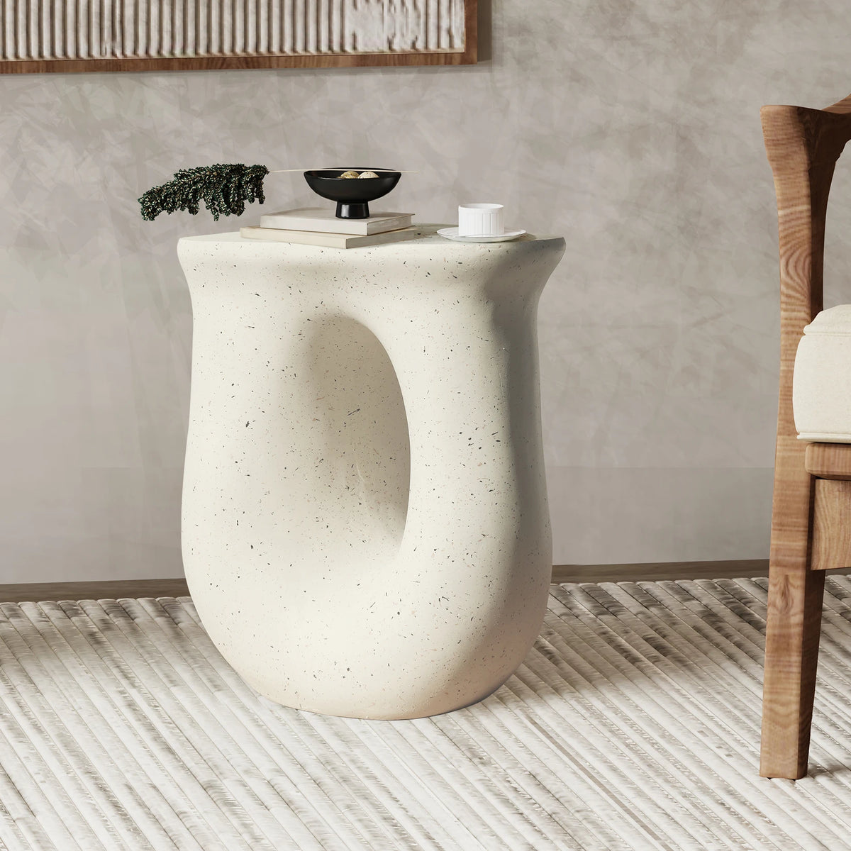 U-shaped off-white concrete side table beside a chair