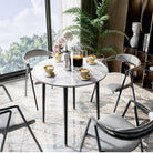 Round sintered stone table by a window