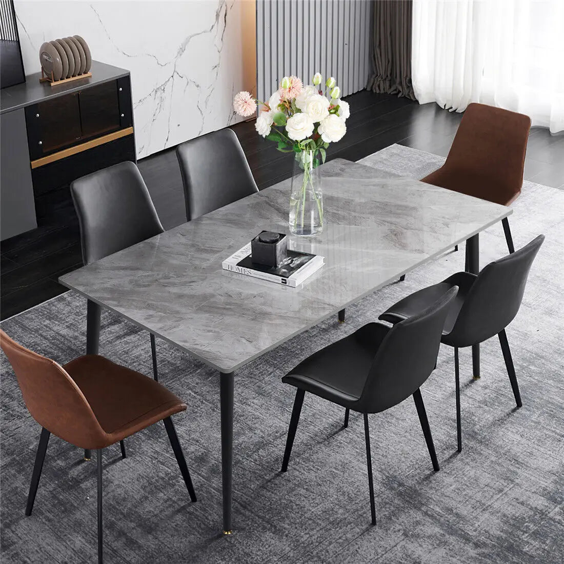 Grey sintered stone dining table with black chairs